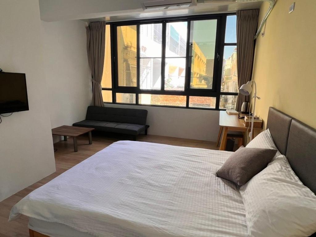 Hu-nei茄萣黄金海岸民宿的一间卧室设有一张床和一个大窗户