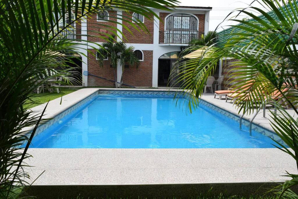 库奥特拉莫雷洛斯Tequesquitengo, Morada del sol的一座大蓝色游泳池,位于房子前