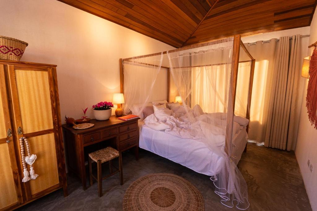 伊瓜苏Alma Iguassu的一间卧室配有一张天蓬床和一张书桌