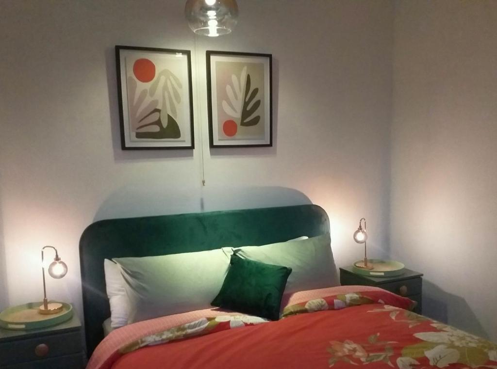 赫尔JESMOND House B&B room 1的一间卧室配有一张带绿色床头板的床和两盏灯。