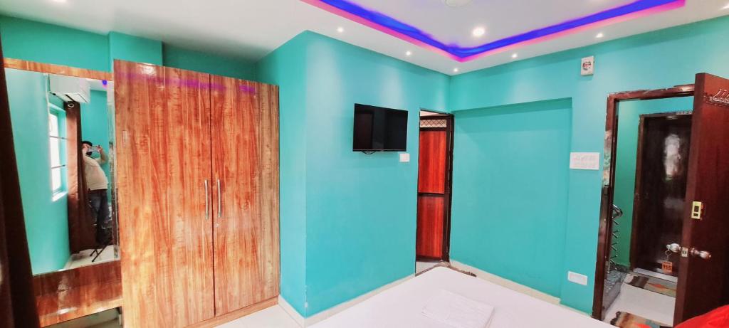瓦拉纳西Hotel Ananya Inn的一间拥有蓝色和绿色墙壁及镜子的客房
