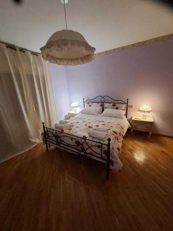 阿韦扎诺Residence Claudia的卧室配有一张床和两盏灯,铺有木地板。