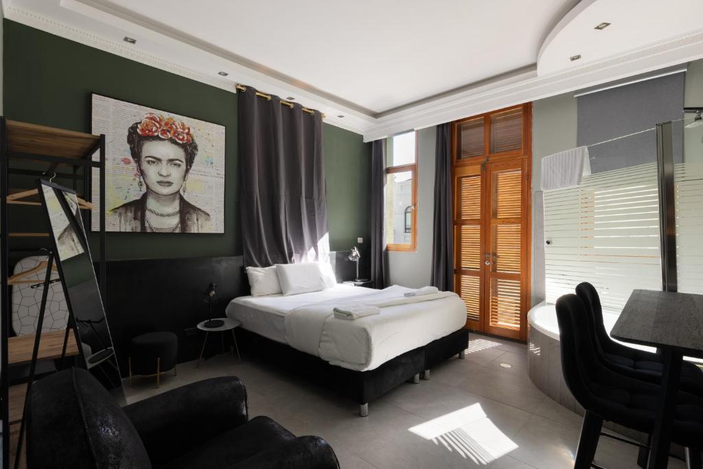 特拉维夫Residence Suites BY RAPHAEL HOTELS的卧室配有一张床和一张桌子及椅子