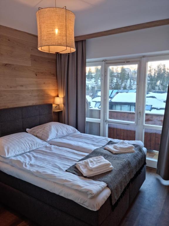 巴德加斯坦The Lodge at Bad Gastein的一间卧室设有一张床和一个大窗户