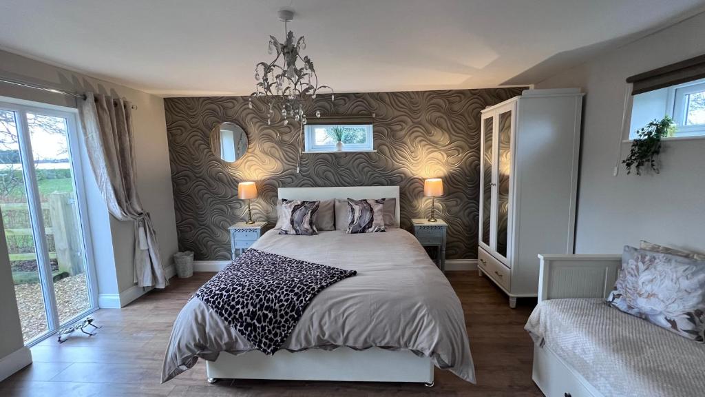 科宁斯比Runway Cottage的一间卧室配有一张大床和一个吊灯。