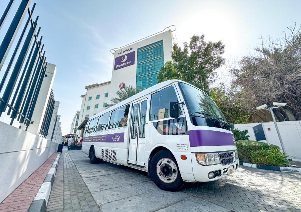迪拜迪拜国际机场普瑞米尔酒店的停在大楼前的白色巴士