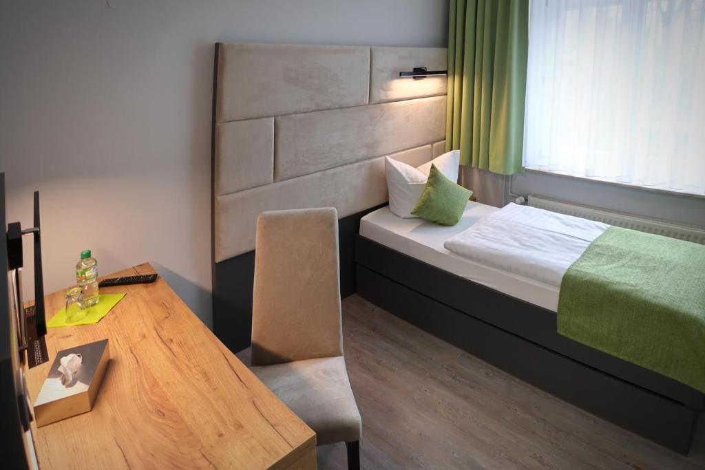 沃尔特斯多夫科拉尼克斯博格餐厅酒店的客房设有一张床、一张桌子和一张桌子。