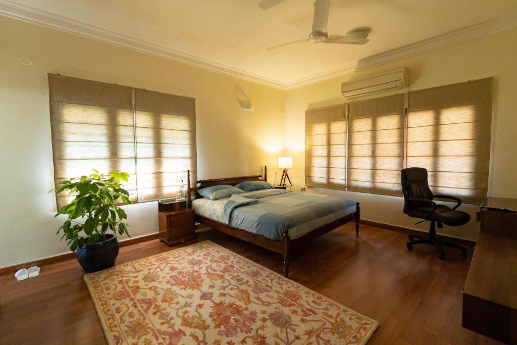 班加罗尔Luho 187的一间卧室配有一张床、一把椅子和窗户。