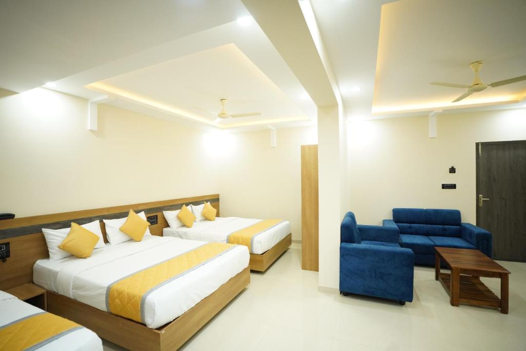 门格洛尔Hotel Mangalore Stay INN的酒店客房,设有两张床和一张蓝色椅子