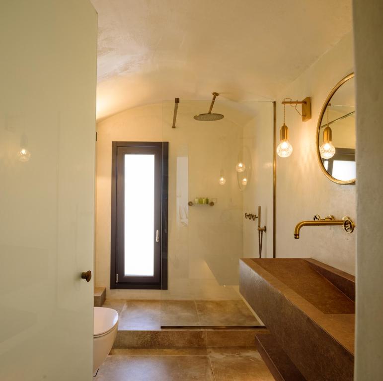 易莫洛林LF Suites & Villas的一间带水槽、卫生间和镜子的浴室