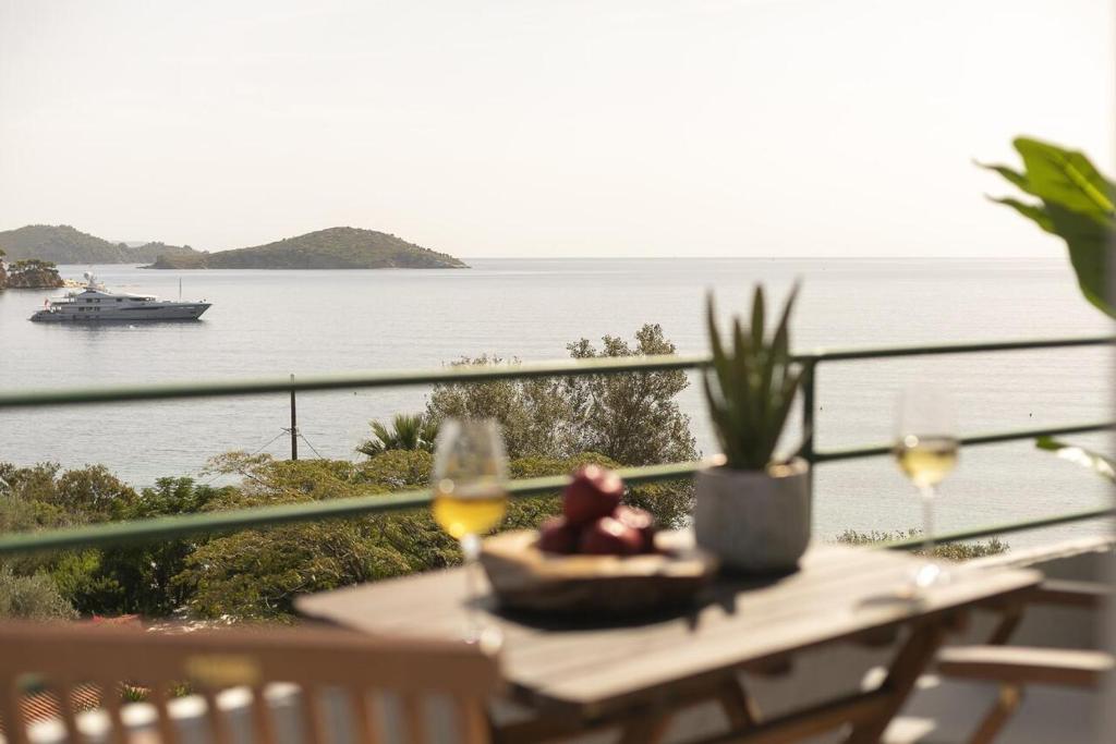 梅加利阿莫斯Nimfi Hotel, Skiathos的酒杯桌子,享有水景