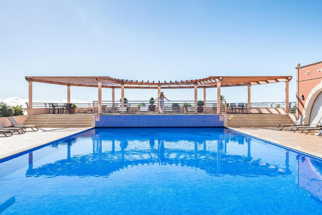 丰沙尔Villa Sea Renity - Palheiro Village by ALMA Holiday Rentals的一个带凉亭和蓝色海水的游泳池
