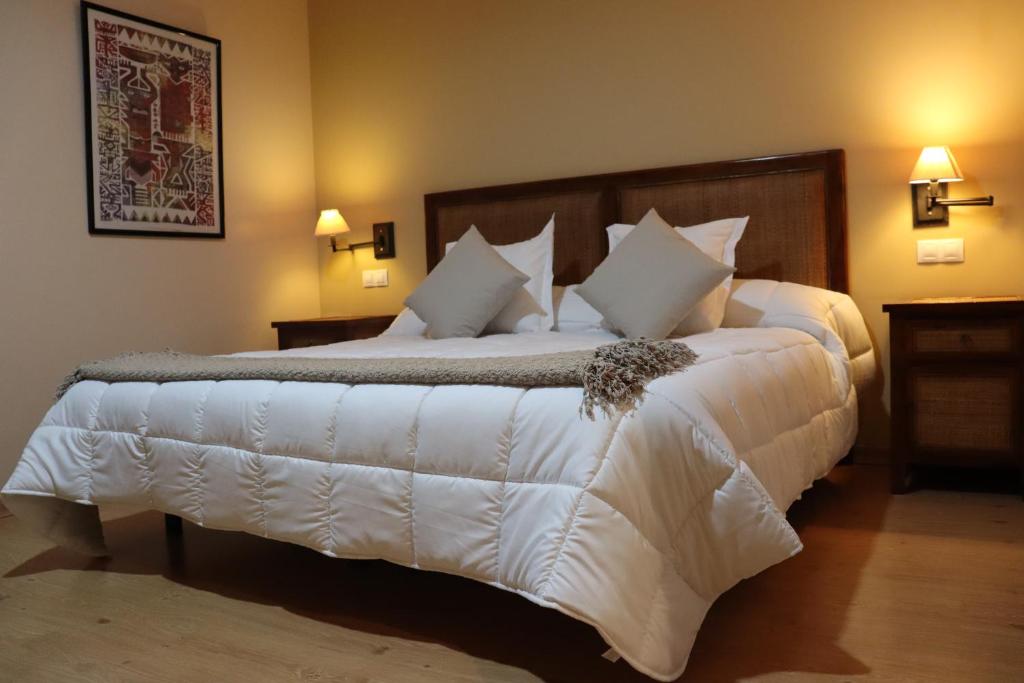 巴雷罗斯巴尔肯圣巴托洛酒店的卧室配有一张带白色床单和枕头的大床。