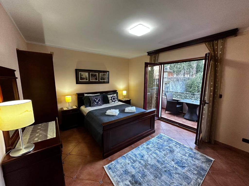 布德瓦Villa Beatrix Budva的一间卧室设有一张床,并有通往阳台的门