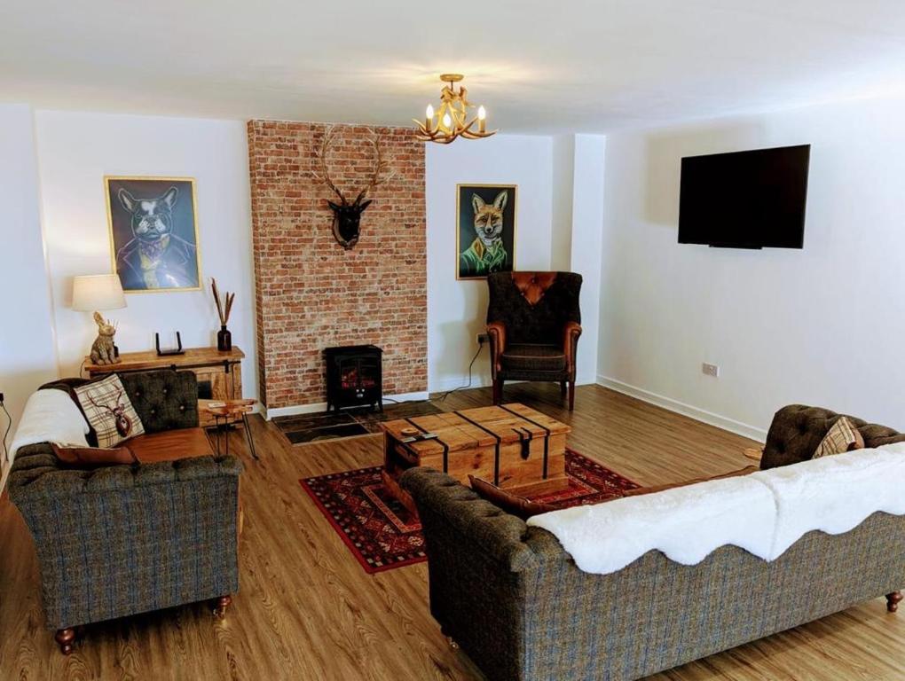 利德尼Country Lodge Retreat的客厅设有两张沙发和一个壁炉