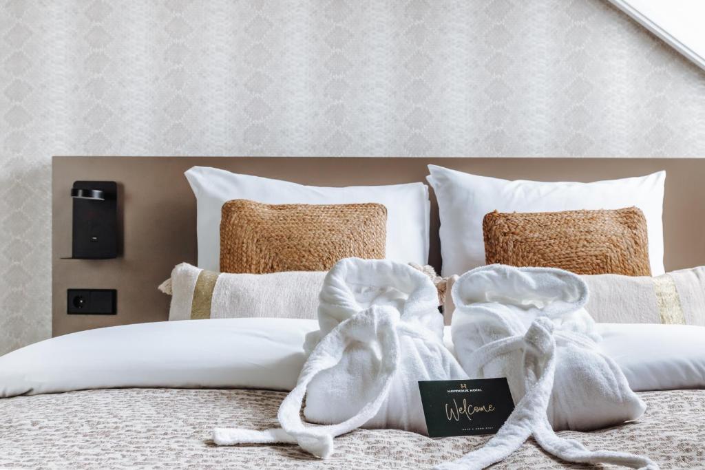 斯希丹Havendijk Hotel的一张带白色毛巾和枕头的床