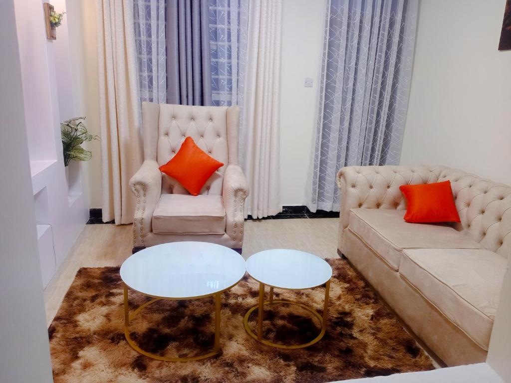 Langata RongaiSpringStone executive apartment Rm 4的客厅配有沙发和2张桌子