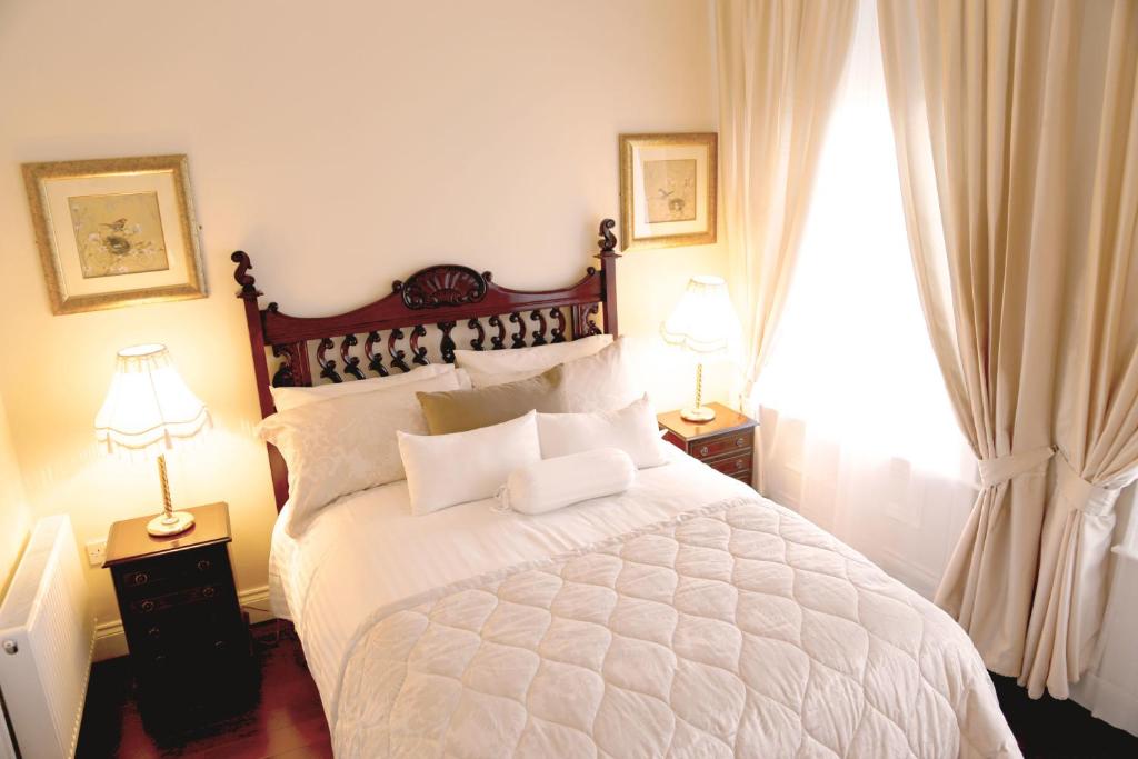 伦敦德里8号联排别墅住宿加早餐旅馆的一间卧室配有一张带两盏灯的大型白色床。