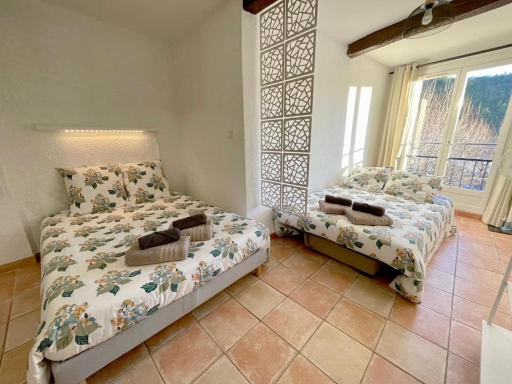里耶Côté Place的一间卧室设有两张床和窗户。