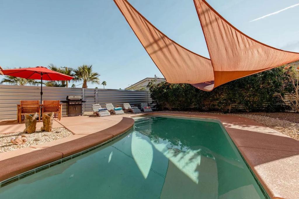 棕榈泉The Yorba Oasis w/Pool的一个带遮阳伞的游泳池和庭院