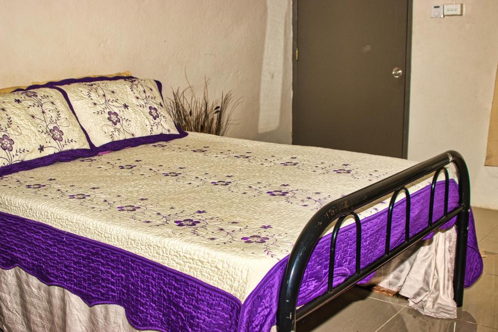 NausoriGuddy’s Riverside Cottage的一张带紫色和白色床单及枕头的床