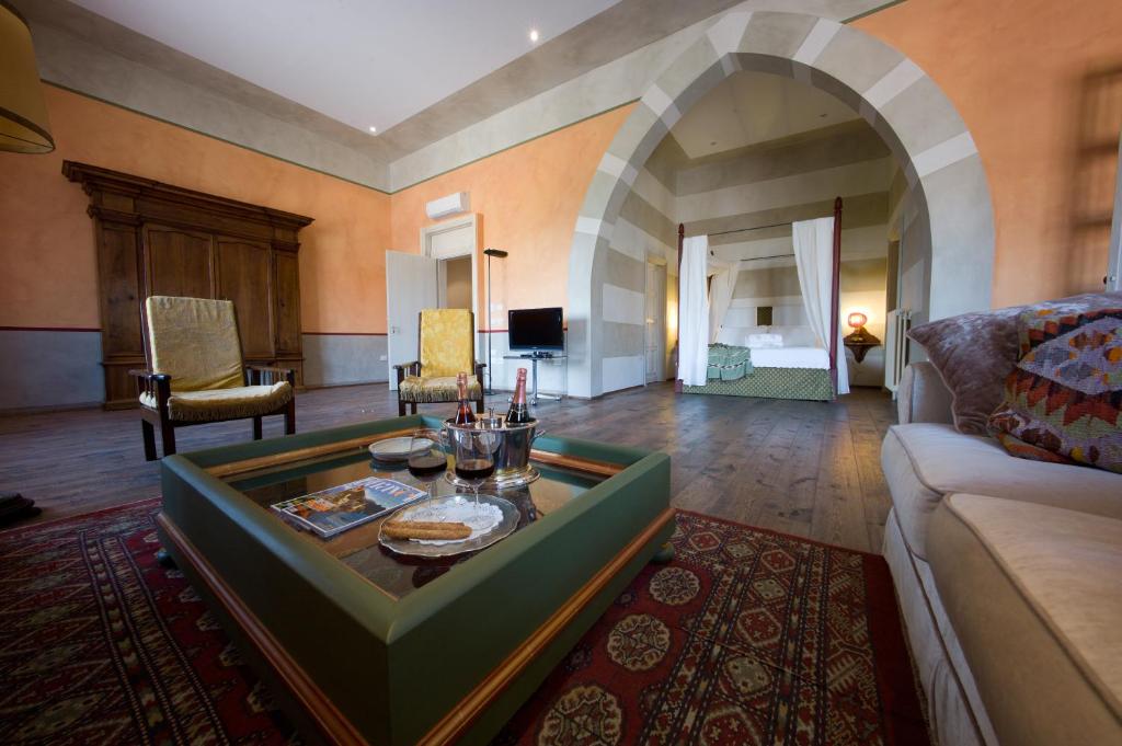 曼托瓦卡斯提格里尼帕拉佐豪华套房旅馆的客厅配有沙发和桌子