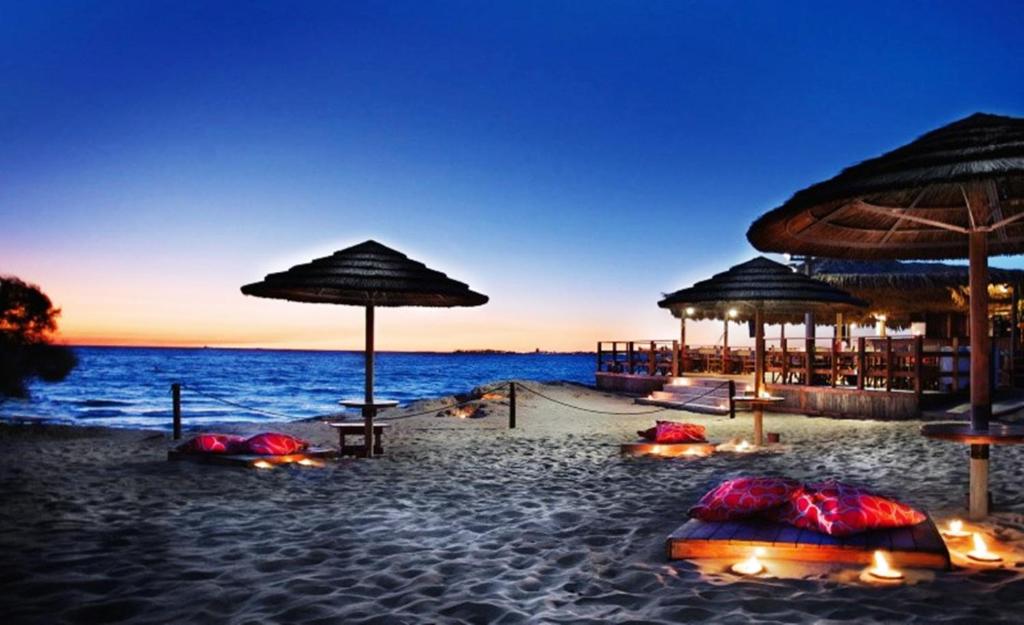 加利波利安可亚住宿加早餐旅馆的海滩上,在晚上有遮阳伞和海洋