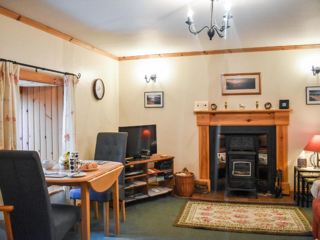 OllachThe Cottage的客厅配有桌子和壁炉
