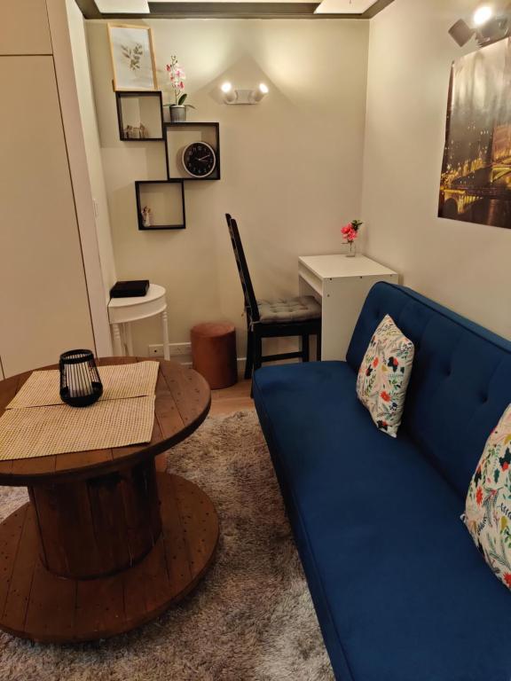 巴黎Charmant studio fonctionnel的客厅配有蓝色的沙发和桌子