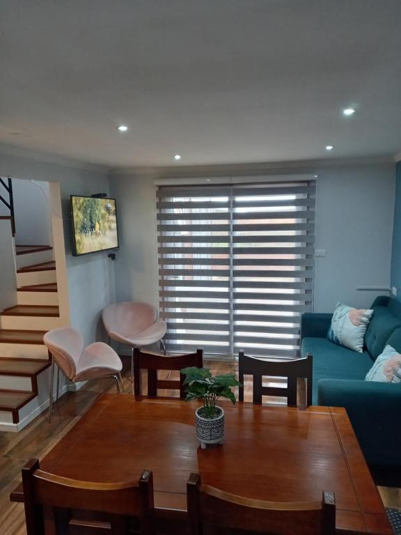 特木科Cabañas y Departamentos Las Palmas, Temuco Depto 3的客厅配有蓝色的沙发和桌子