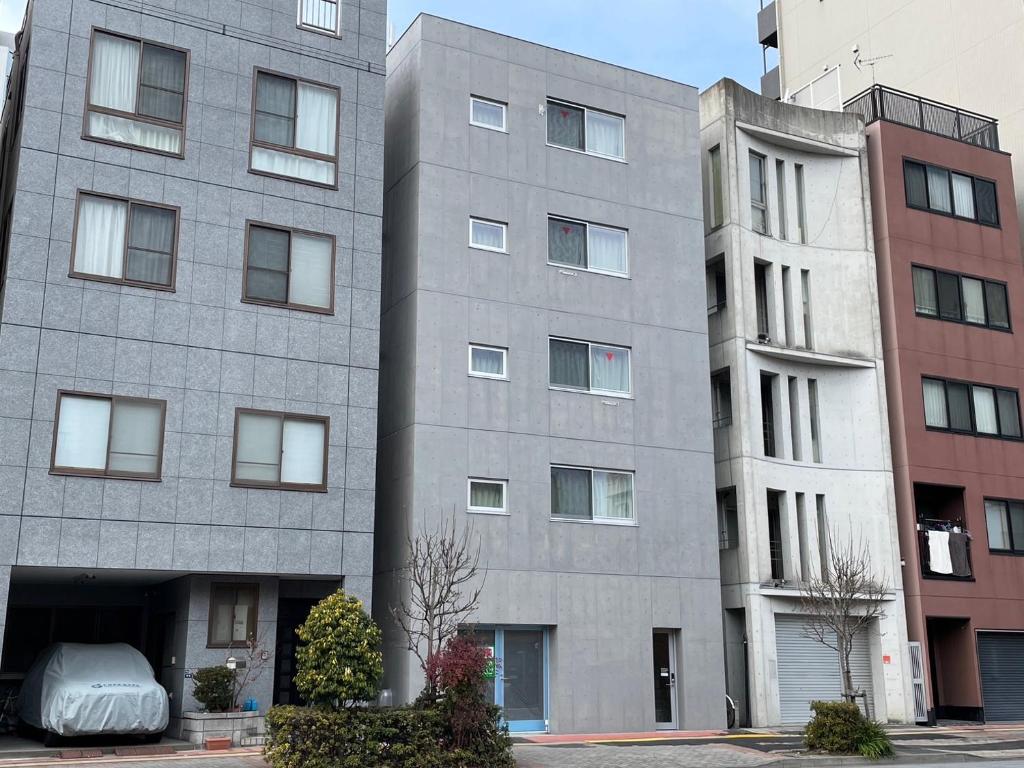东京PRISM Inn Komagata Asakusa的两座高楼旁的灰色建筑