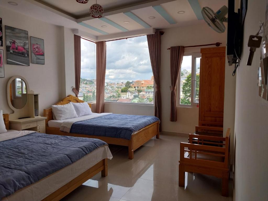 大叻卡姆里民宿的酒店客房设有两张床和大窗户。