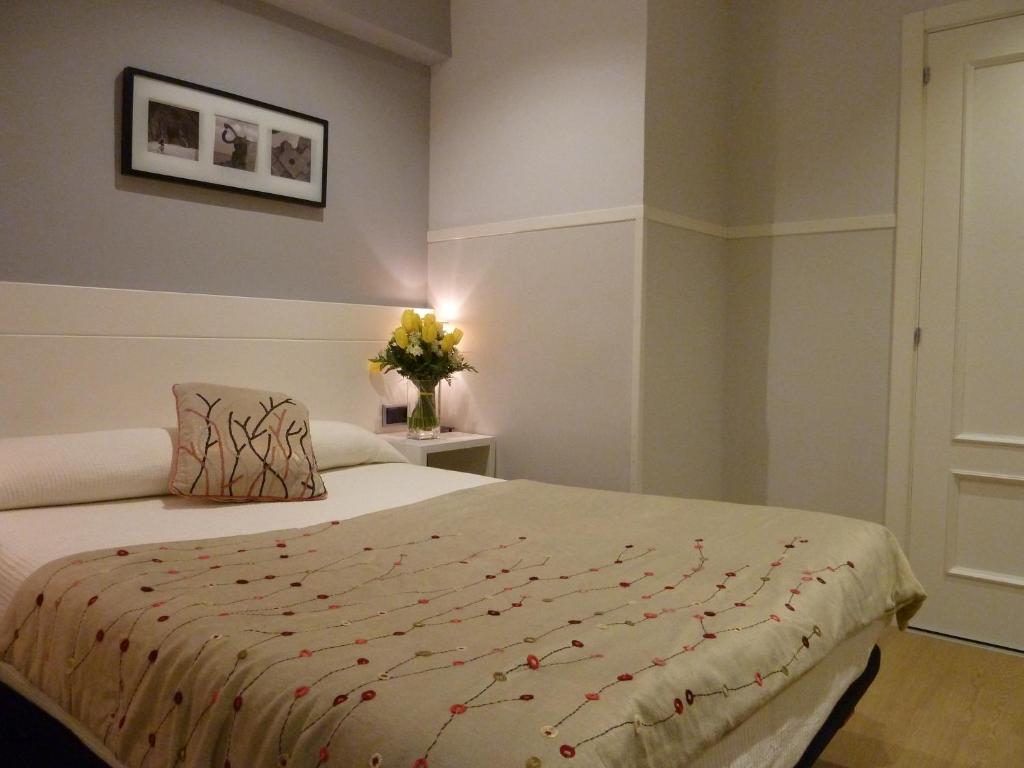 圣塞瓦斯蒂安加拉特酒店的一间卧室,配有一张床和花瓶