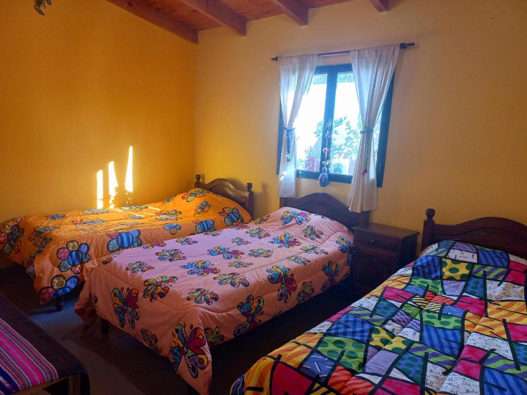 麦马拉Casa Munay的配有蜡烛和窗户的客房内的两张床
