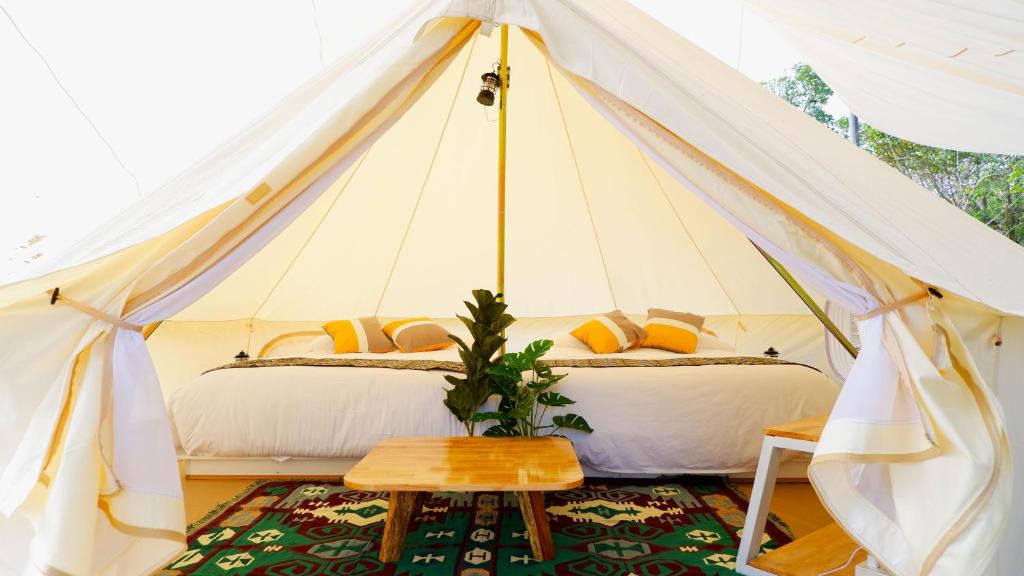 Klang DongThe Wild Khao Yai的帆布帐篷内一间卧室,配有两张床