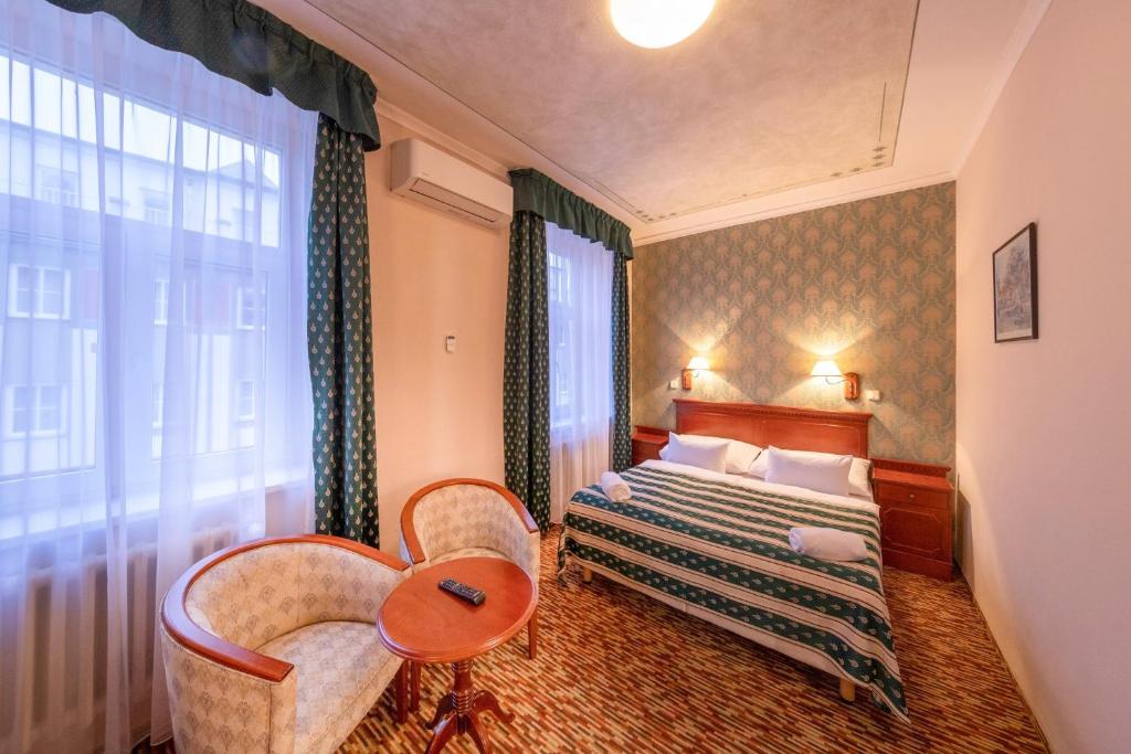 布拉格Hotel Meteor Plaza Prague的酒店客房设有床和窗户。