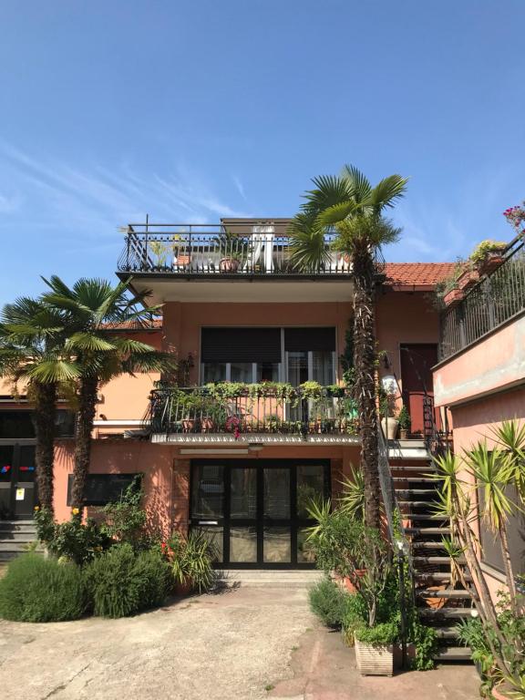 佩罗Appartamento con terrazza e posto auto Libri e Giardini的带阳台和棕榈树的房子