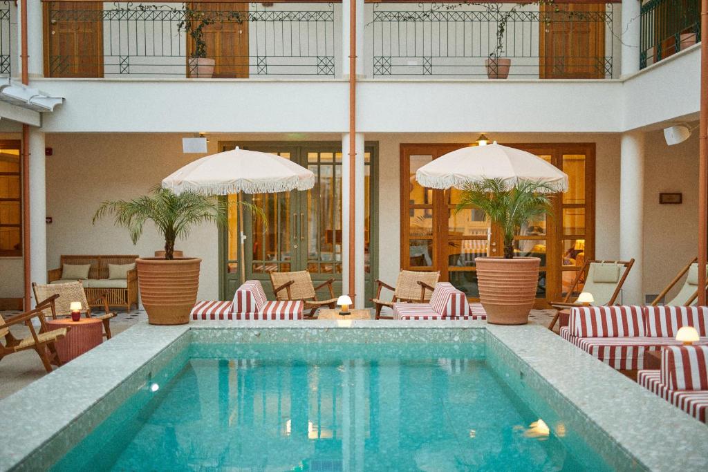 帕诺雷弗卡拉The Agora Hotel - Adults Only的一个带躺椅和遮阳伞的游泳池