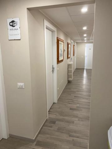 米兰盖拉酒店的办公室的走廊,设有白色的墙壁和木地板