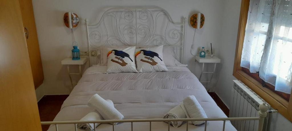 滨海比拉萨尔CASA la PAU的卧室配有一张白色床,枕头上有两只鸟