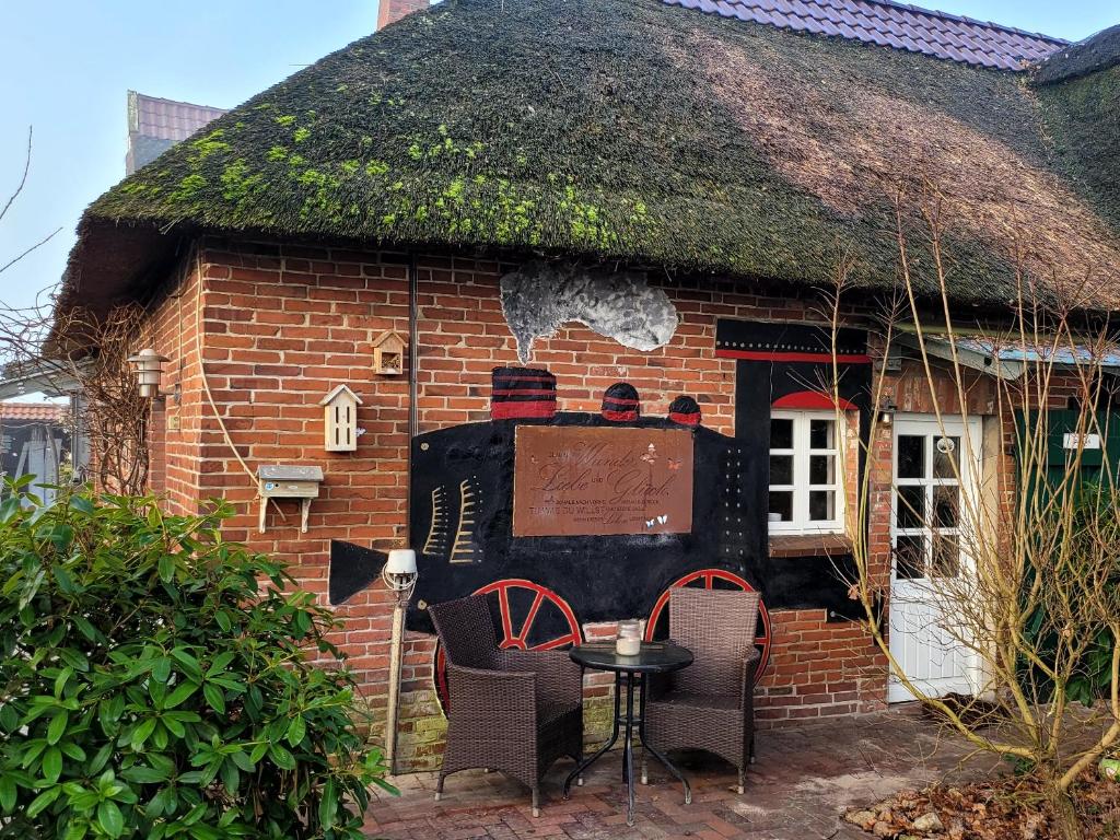 OvelgönneFerienwohnung Glücklich的一座带草屋顶的小砖屋