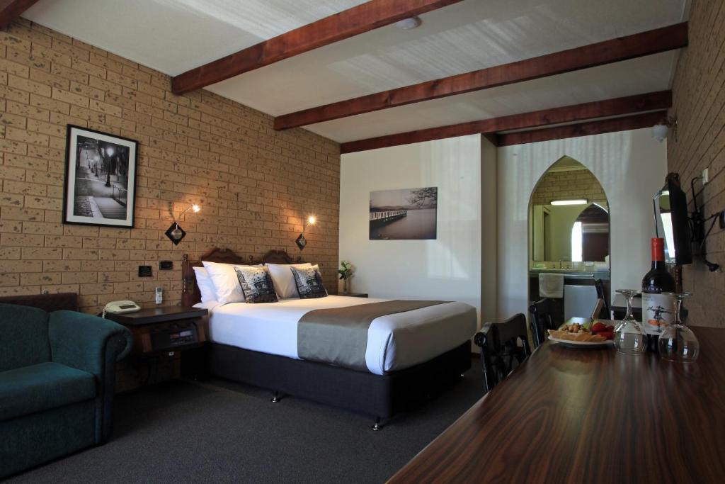 谢珀顿钟塔汽车旅馆的一间卧室配有一张床、一张桌子和一张沙发