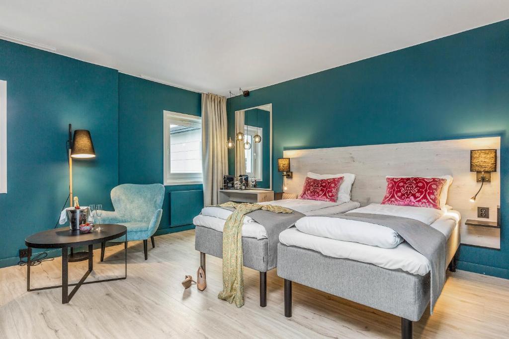 埃尔沃吕姆Thon Partner Hotel Central的卧室拥有蓝色的墙壁,配有一张床和椅子