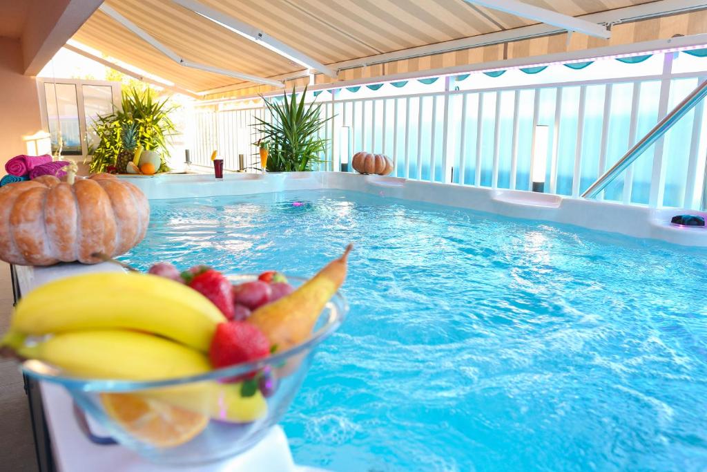 杜布罗夫尼克Apartment Rose Pool Comfort的游泳池旁坐着一碗水果