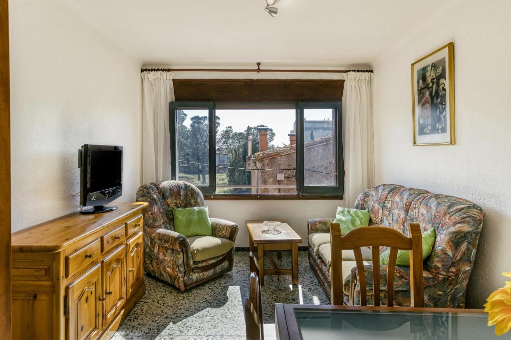 CapmanyCan Picola的客厅配有电视、椅子和窗户