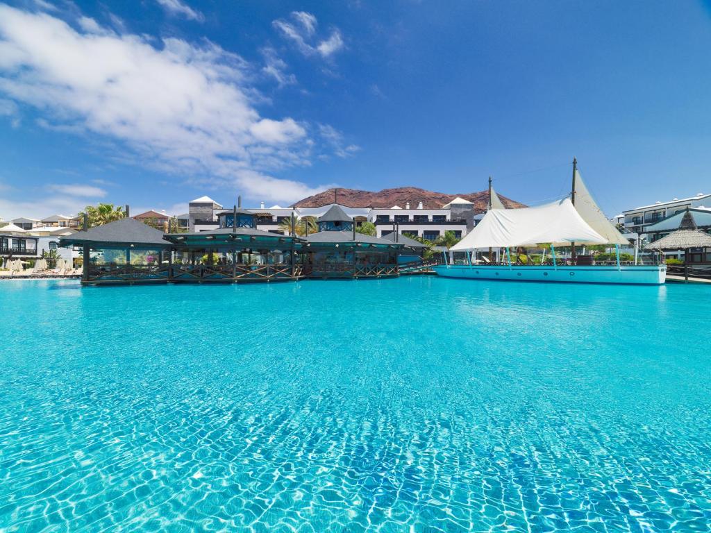 普拉亚布兰卡H10鲁比肯皇宫酒店的度假村内的一个大型蓝色海水游泳池