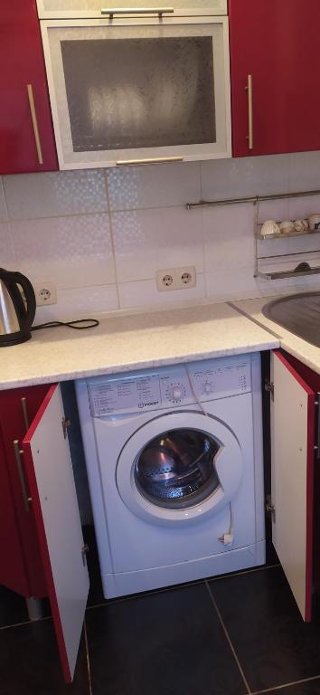 第聂伯罗2кімнатні апартаменти район Даффі的厨房内的洗衣机配有微波炉