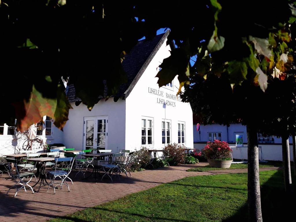 LiselejeLiseleje Badehotel的前面有桌椅的白色建筑