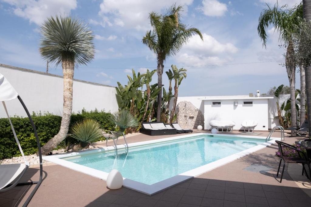 加利波利Villetta Del Salento Exclusive B&B的棕榈树庭院内的游泳池
