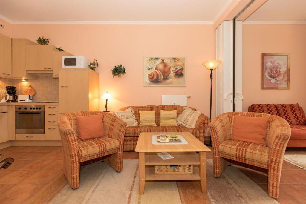 奥斯赛拜-屈隆斯博恩Duenenschloss-Haus-1-Wohnung-12-487的客厅配有沙发、椅子和桌子